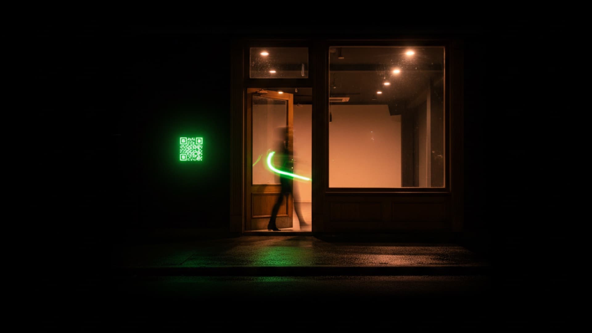 A dance studio doorway at night with a glowing green code beside the door